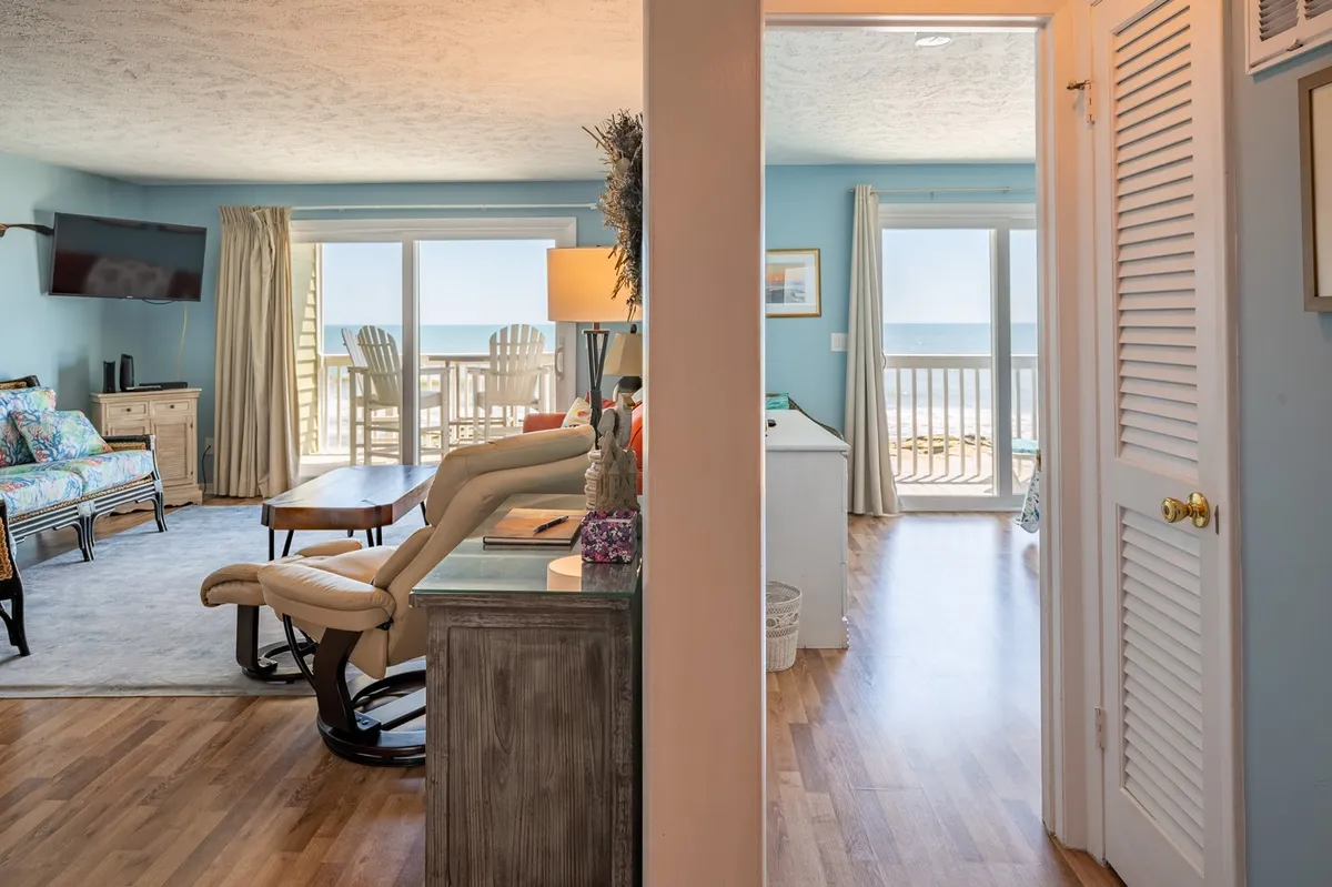 A spacious living area featuring large floor-to-ceiling windows that frame an expansive ocean view. Plush, comfortable seating and carefully chosen decorative pieces exude casual sophistication. The tranquil color palette and open design invite relaxation and togetherness.
